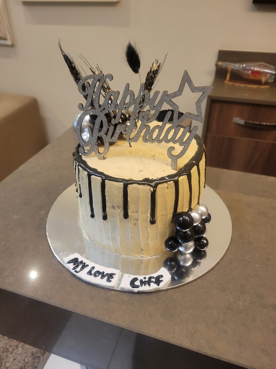 Birthday cake with black drip and silver spheres